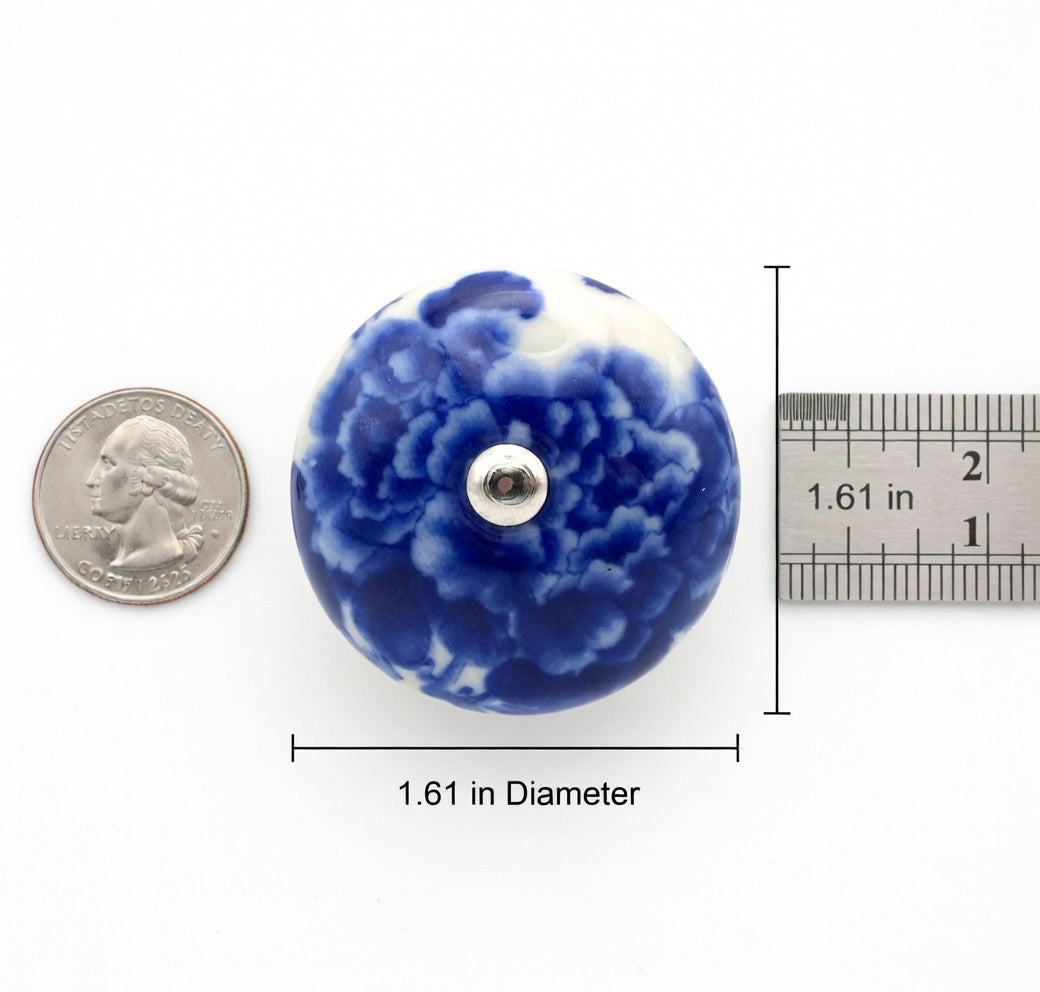 Blue floral ceramic knob with a quarter for scale on a white background