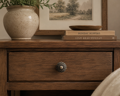 Antique bronze geometric cabinet knob installed on a dark wood dresser in a sophisticated interior.