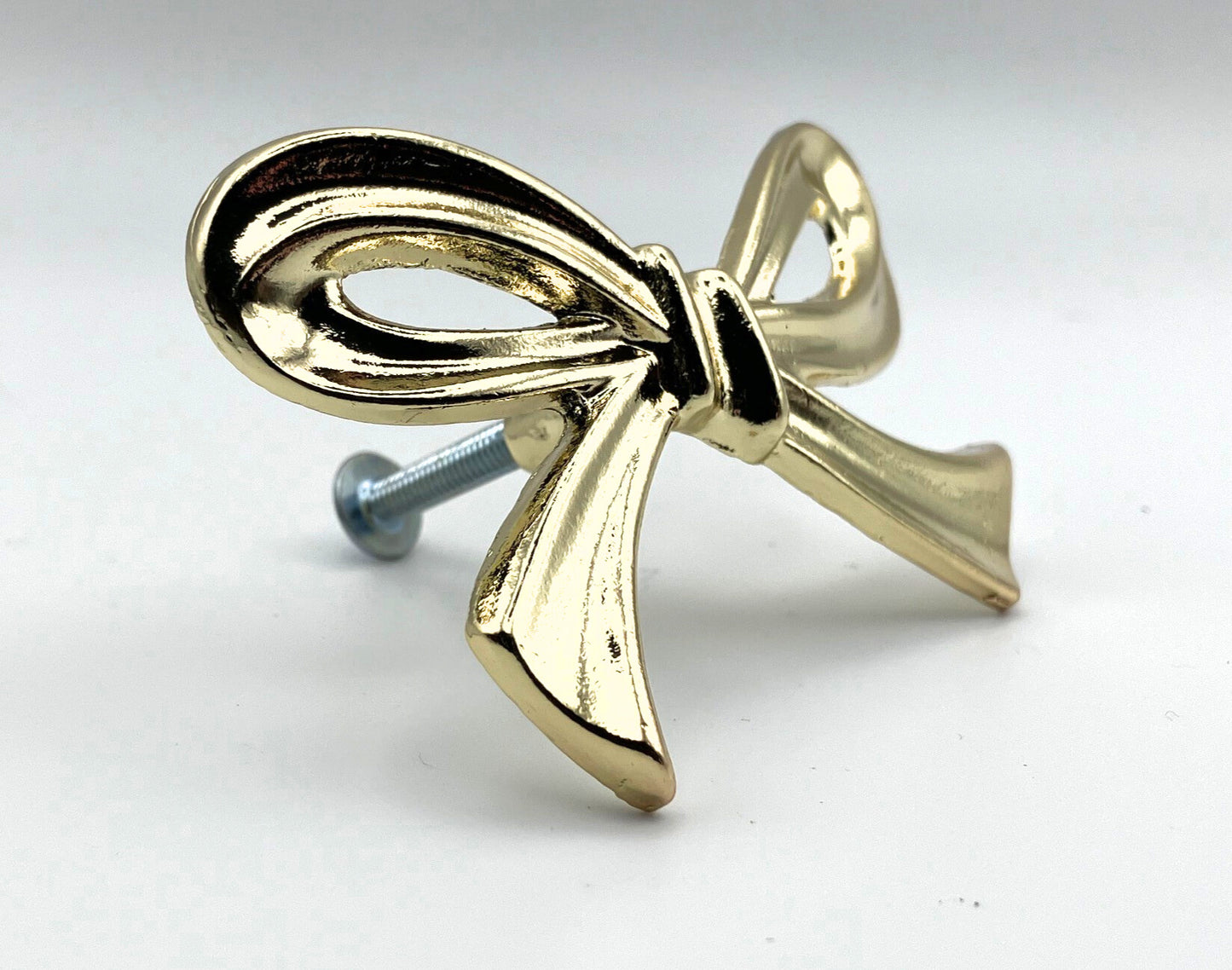 Brass gold bow knob on a white background