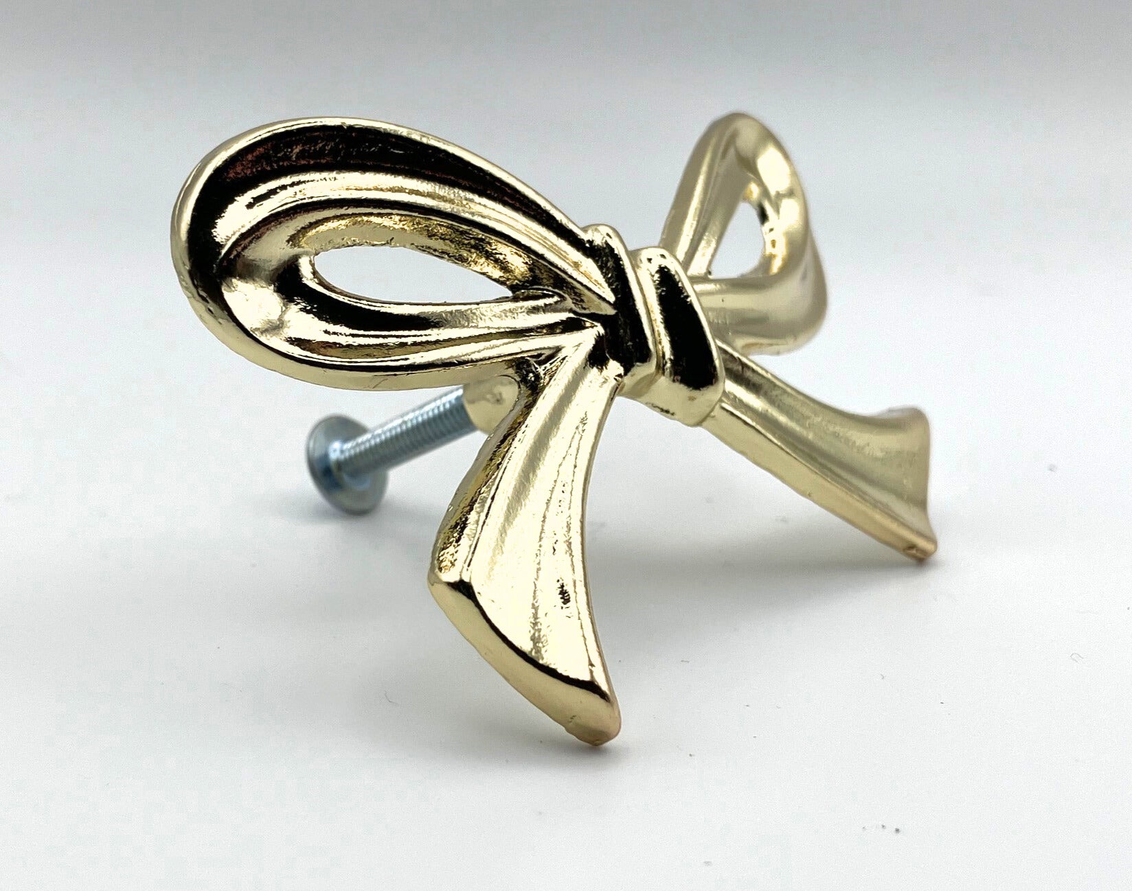 Brass gold bow knob on a white background