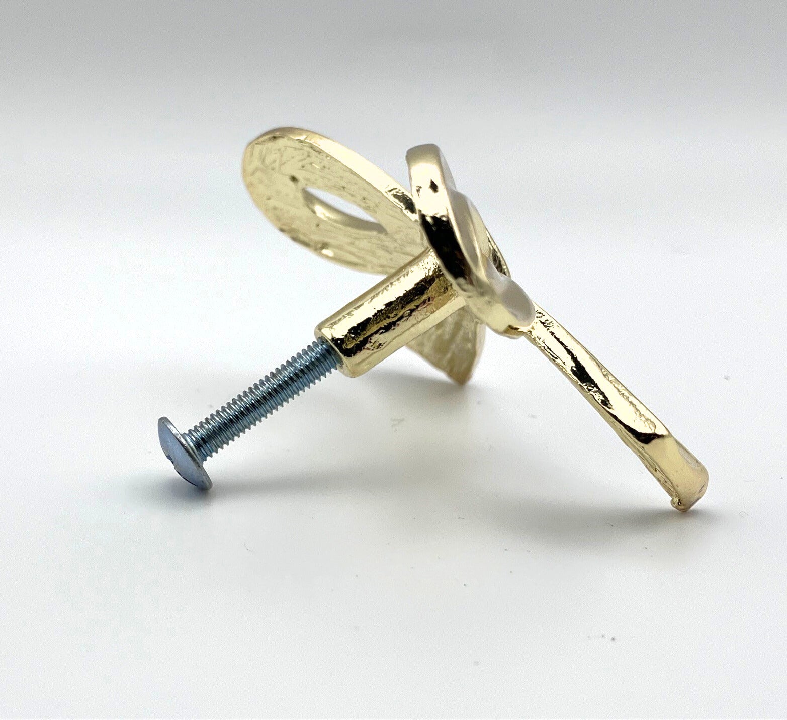 Brass gold bow knob on a white background