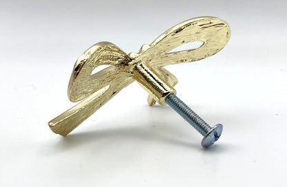 Gold bow-shaped cabinet knob on a white background