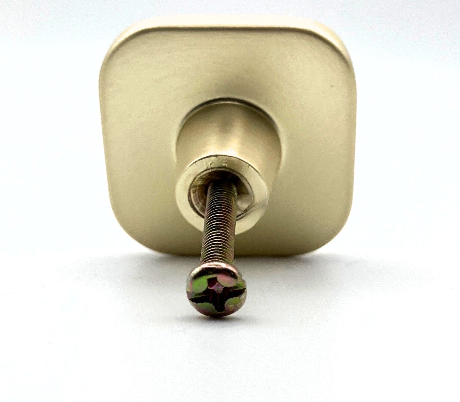 Square with rounded corners shaped knob with off-white inset and brass gold metal trim