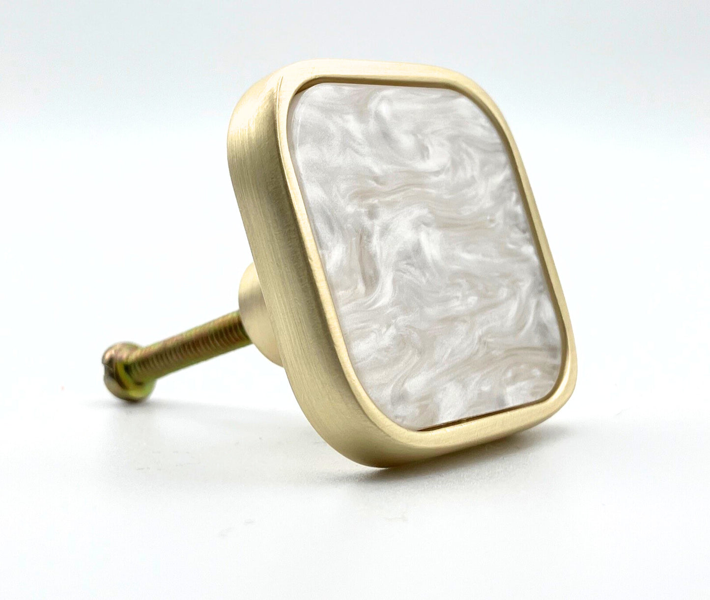 Decorative knob with gold frame and white marble pattern on a white background