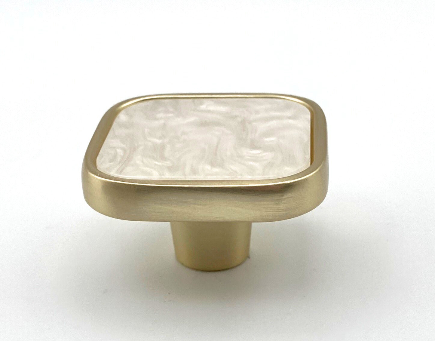 Brass cabinet knob with a white marble texture on a white background