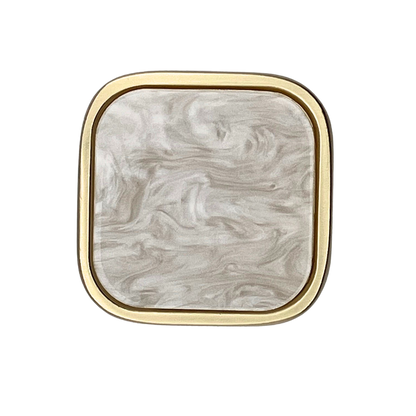 Square with rounded corners shaped knob with off-white inset and brass gold metal trim