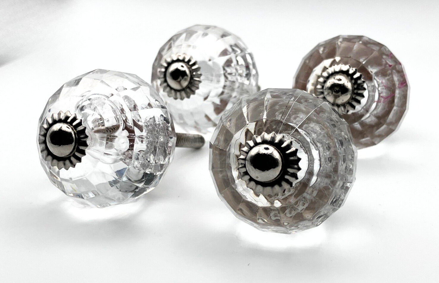 Clear glass knobs with metal centers on a white background