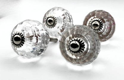 Clear glass knobs with metal centers on a white background