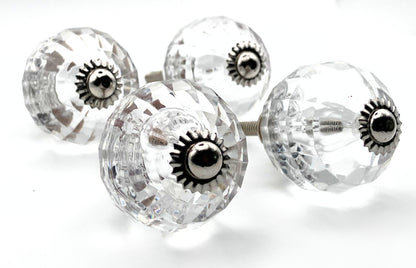 Clear glass knobs with silver central screws on a white background