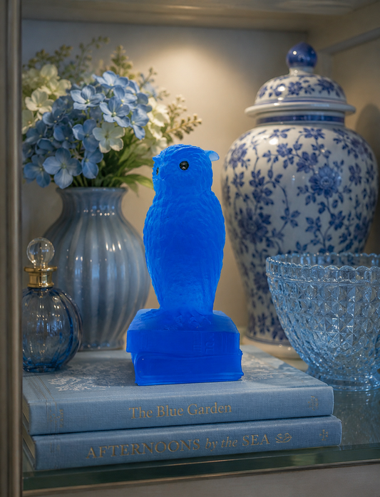 Westmoreland Small blue owl figurine displayed on a shelf with complementary blue and aqua glass decor in a bright collector's vignette.