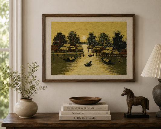 Framed Vietnamese village textile artwork displayed as statement wall décor above a mid-century sideboard.
