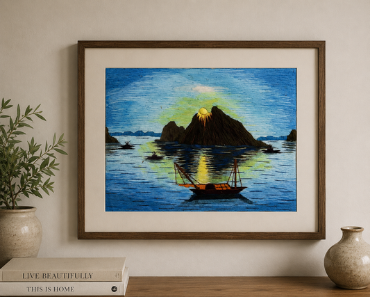 Framed blue vintage silk thread artwork depicting an island landscape displayed on a living room wall.