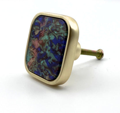 Decorative knob with multicolored stone and gold finish on a white background