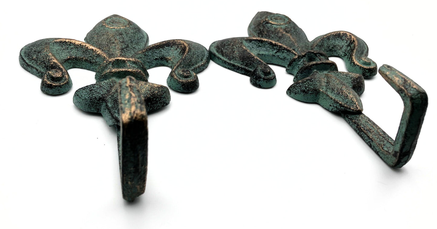 Two decorative metal hooks with a fleur-de-lis design on a white background