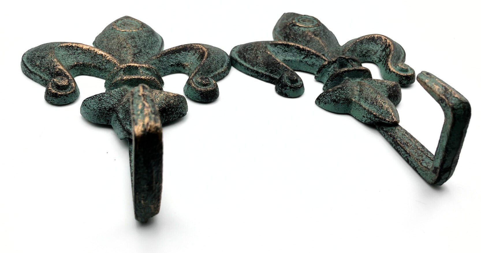 Two decorative metal hooks with a fleur-de-lis design on a white background