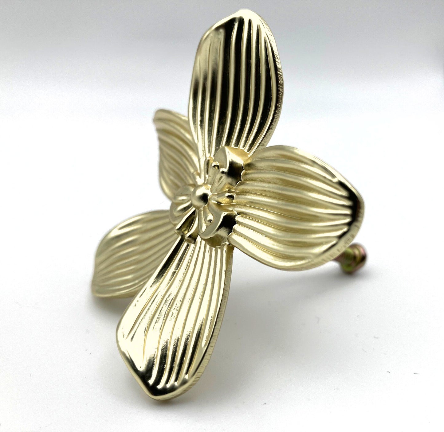 Gold brass flower-shaped knob on a white background