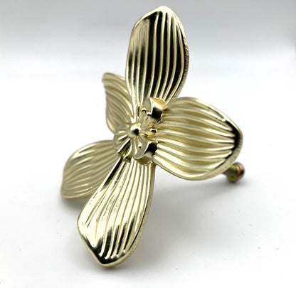 Gold brass flower-shaped knob on a white background