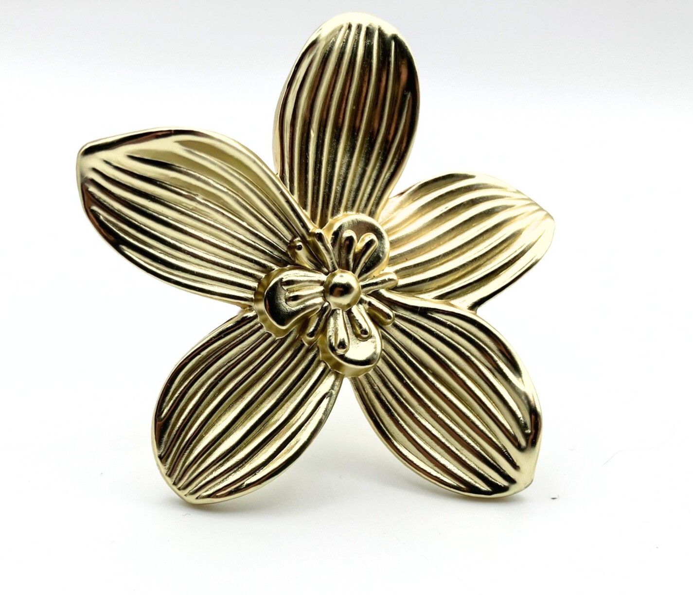 Gold brass flower-shaped knob on a white background