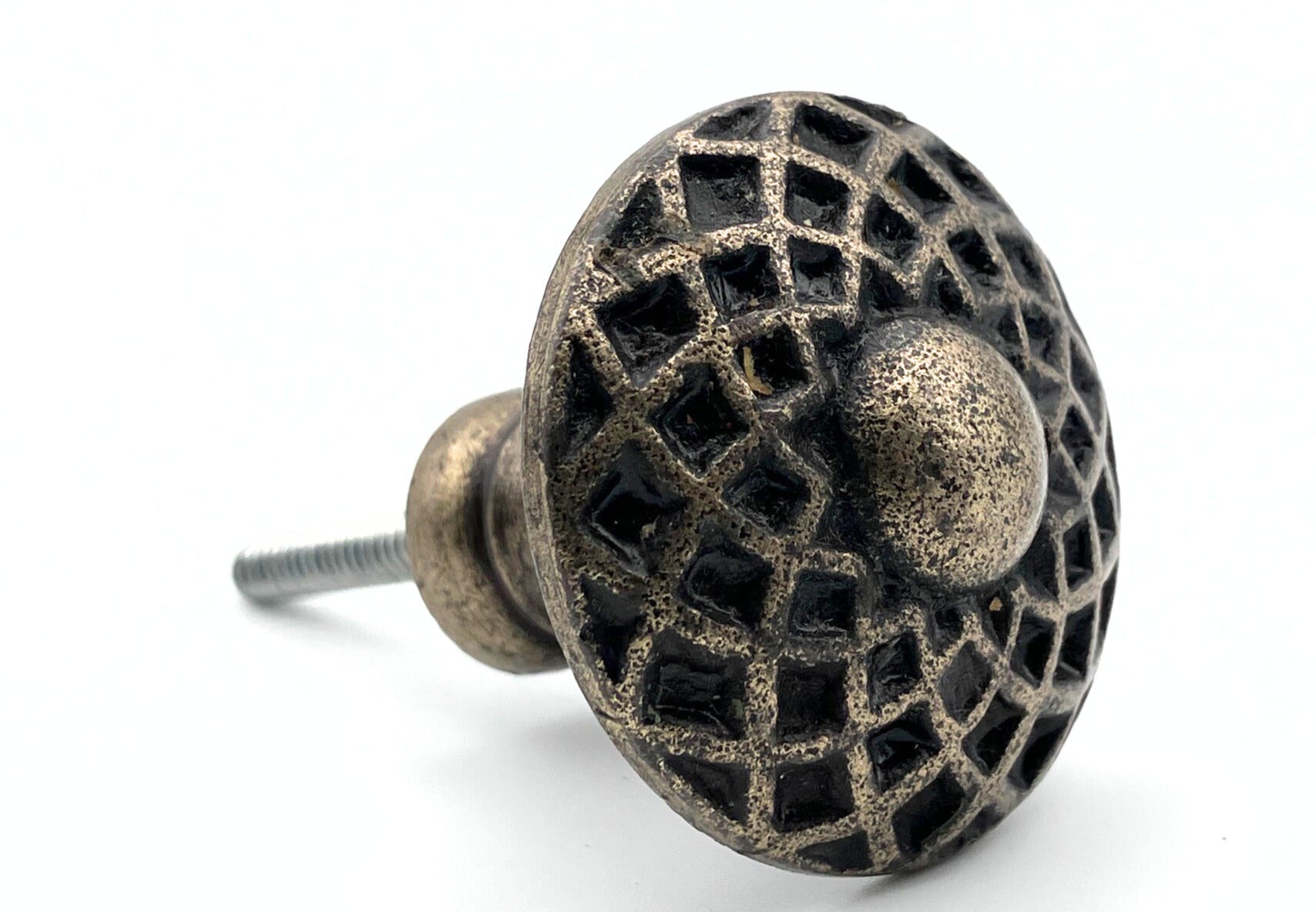 Decorative metal knob with intricate design on a white background