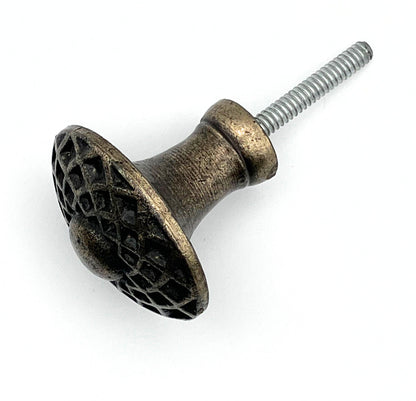 Decorative metal knob with textured surface and screw on a white background