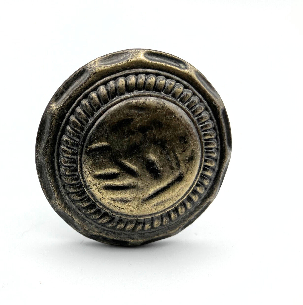 Decorative metal knob with intricate design on a white background