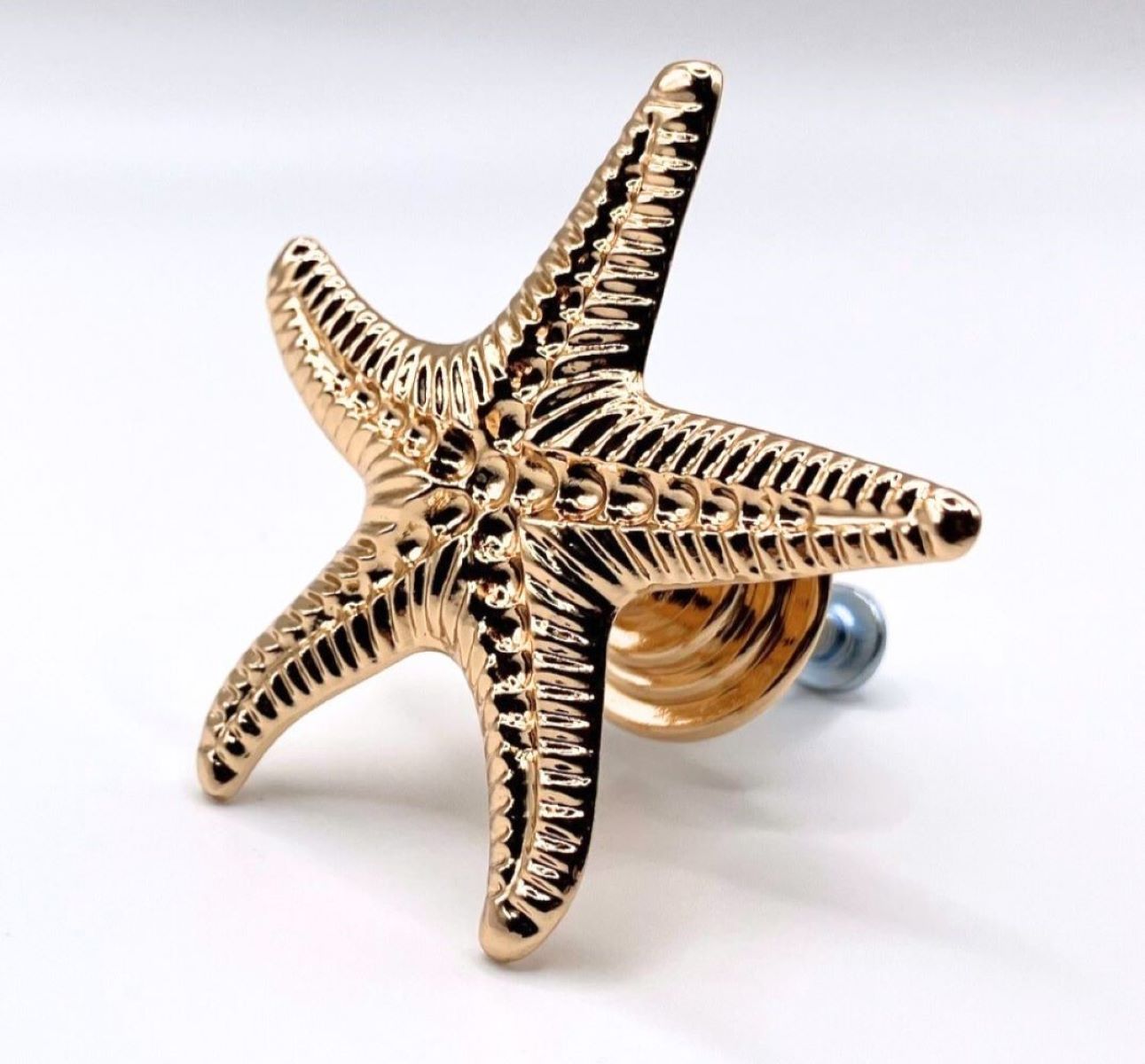 Gold starfish-shaped knob on a white background