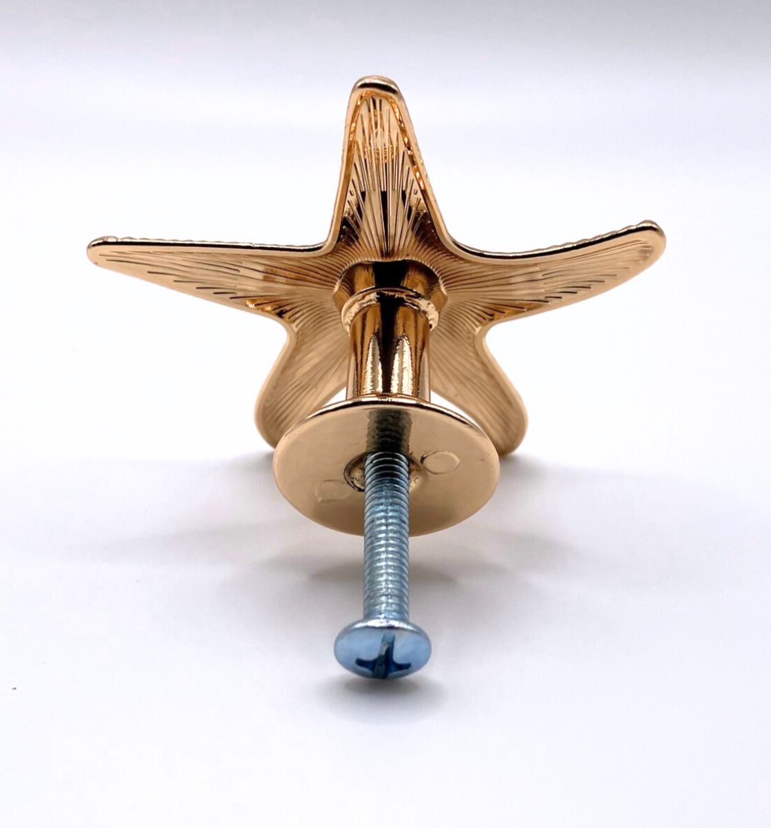 Gold starfish-shaped knob on a white background