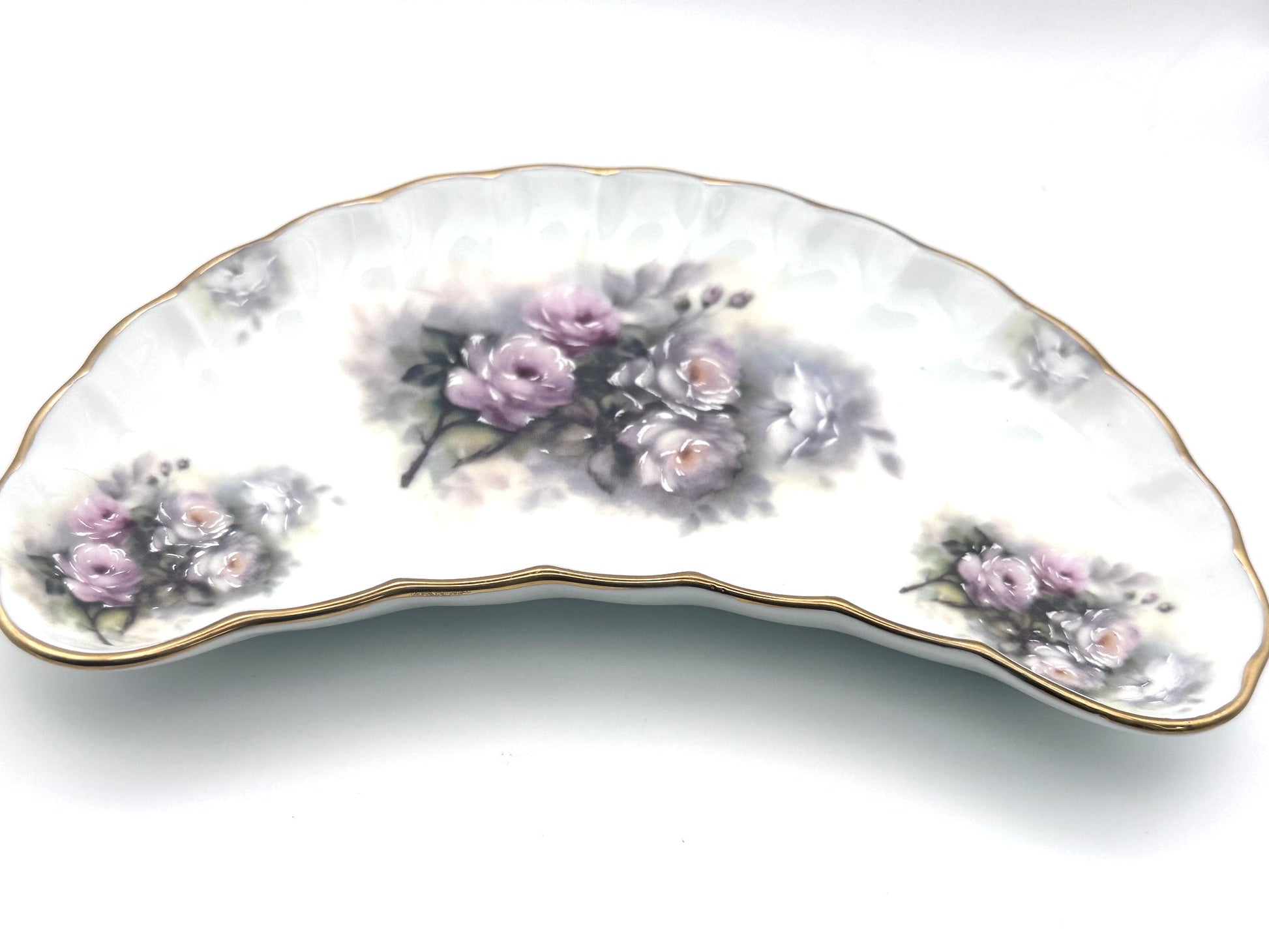 Decorative vintage crescent dish adorned with colorful floral motifs and classic styling
