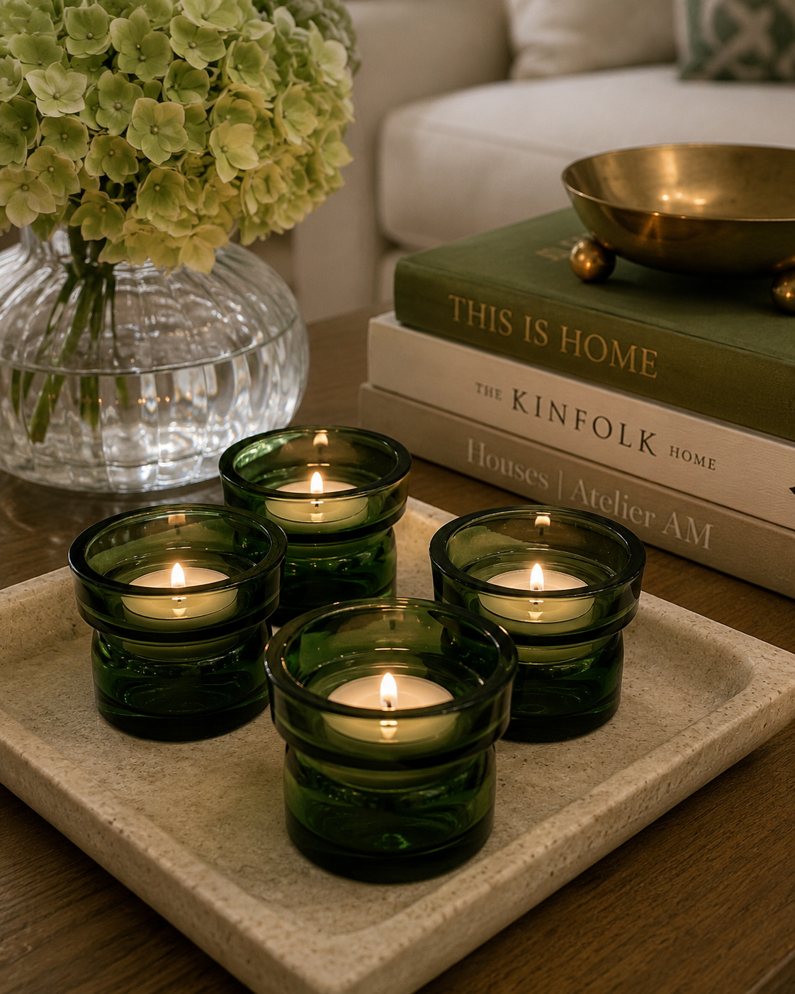 Set of four vintage dark green Dansk glass candle holders styled on a dining table with modern greenery and natural light.