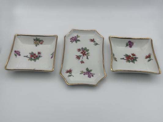 Set of three vintage Limoges trinket trays featuring elegant floral and gold detailing
