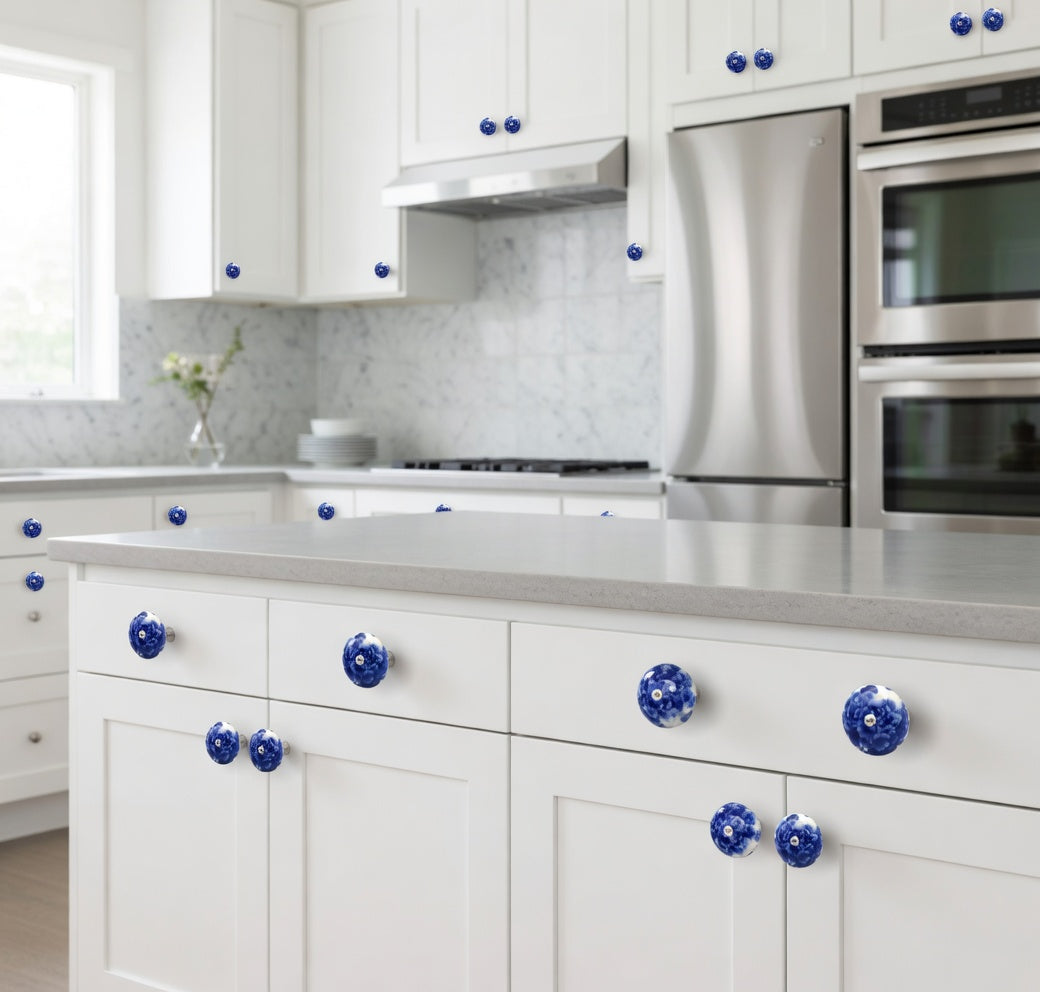 Modern kitchen with white cabinets, blue knobs, and stainless steel appliances.
