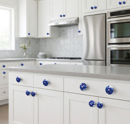 Modern kitchen with white cabinets, blue knobs, and stainless steel appliances.