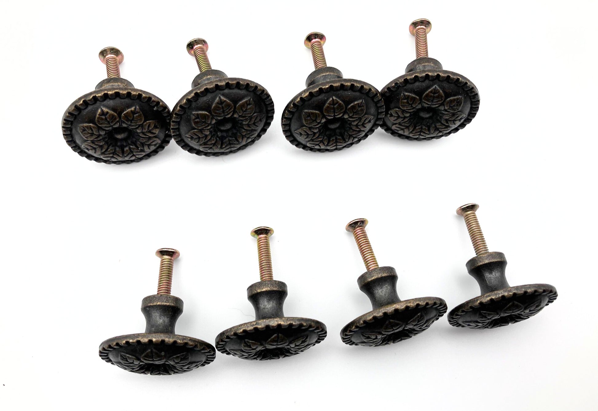 Set of eight decorative cabinet knobs on a white background