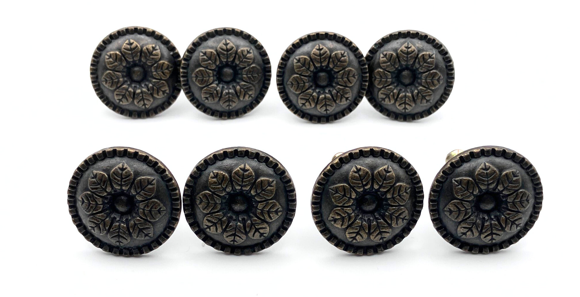 Set of eight decorative black knobs with floral patterns on a white background