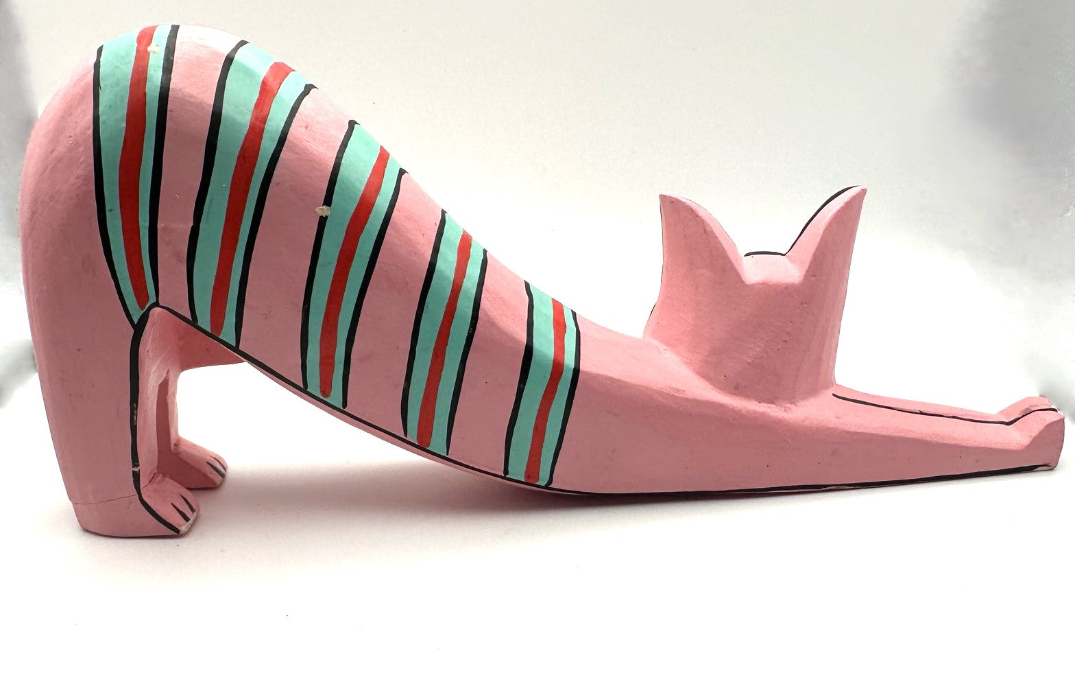 Colorful wooden cat figurines inspired by Laura Burke featuring vibrant pink background and teal and gold accents