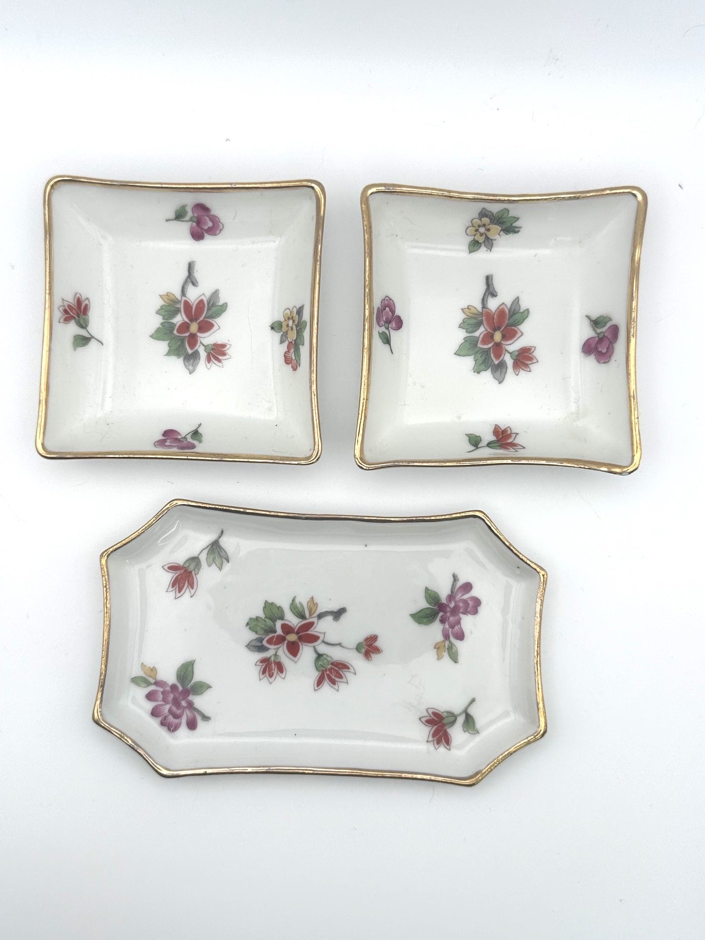 Set of three vintage Limoges trinket trays featuring elegant floral and gold detailing