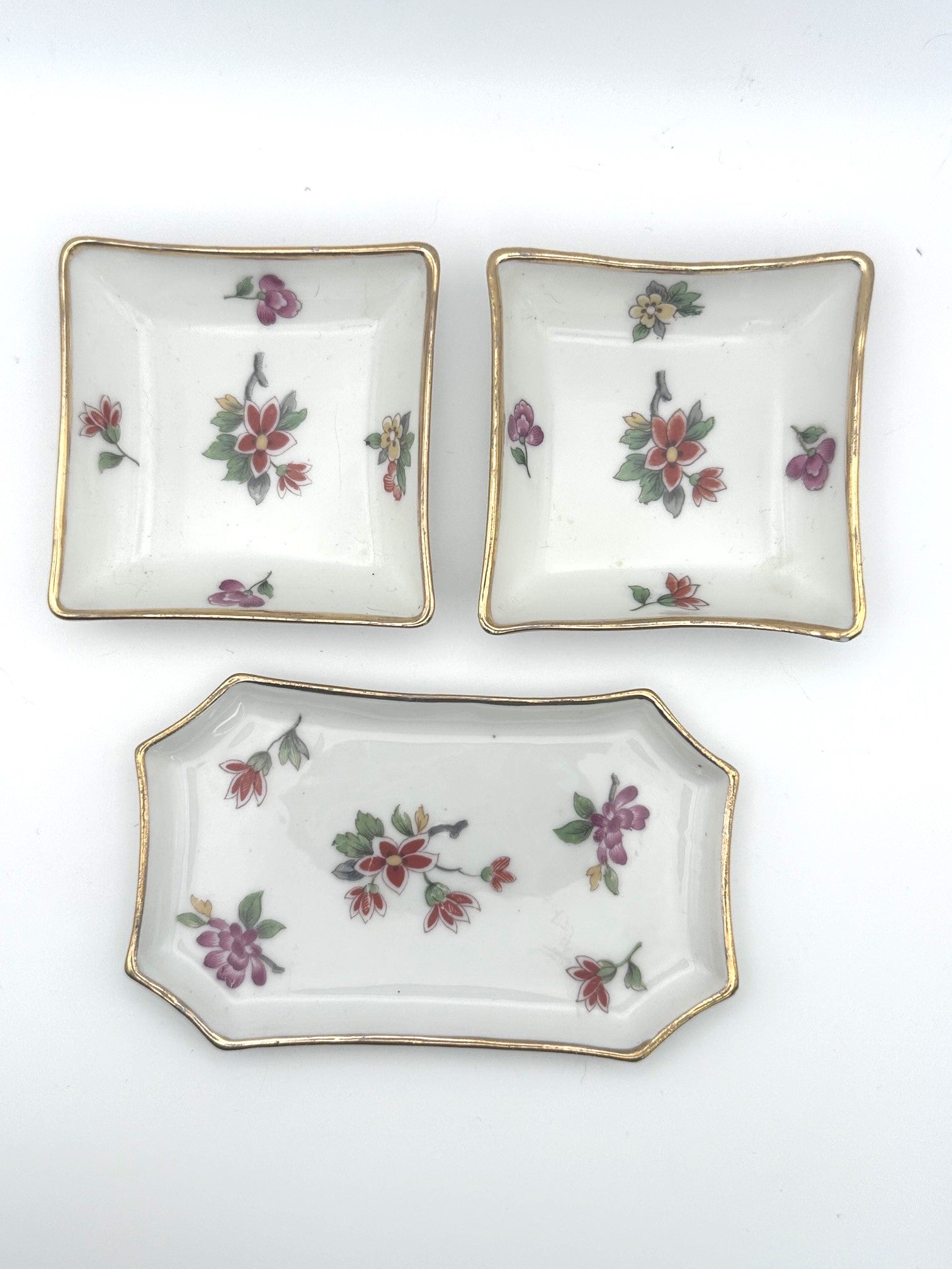 Set of three vintage Limoges trinket trays featuring elegant floral and gold detailing