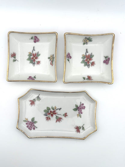 Set of three vintage Limoges trinket trays featuring elegant floral and gold detailing