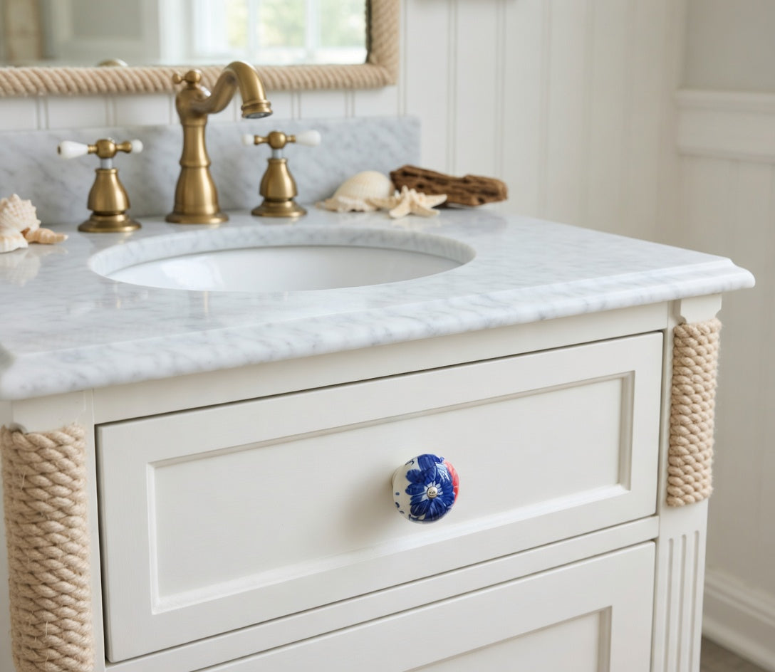 Bathroom vanity with marble countertop, gold faucet, and decorative rope trim.