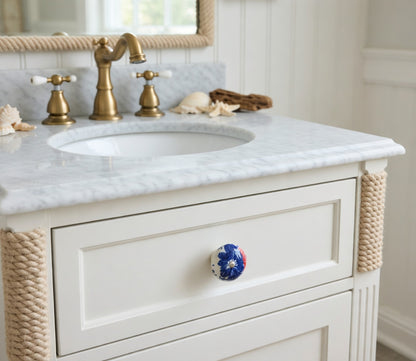 Bathroom vanity with marble countertop, gold faucet, and decorative rope trim.