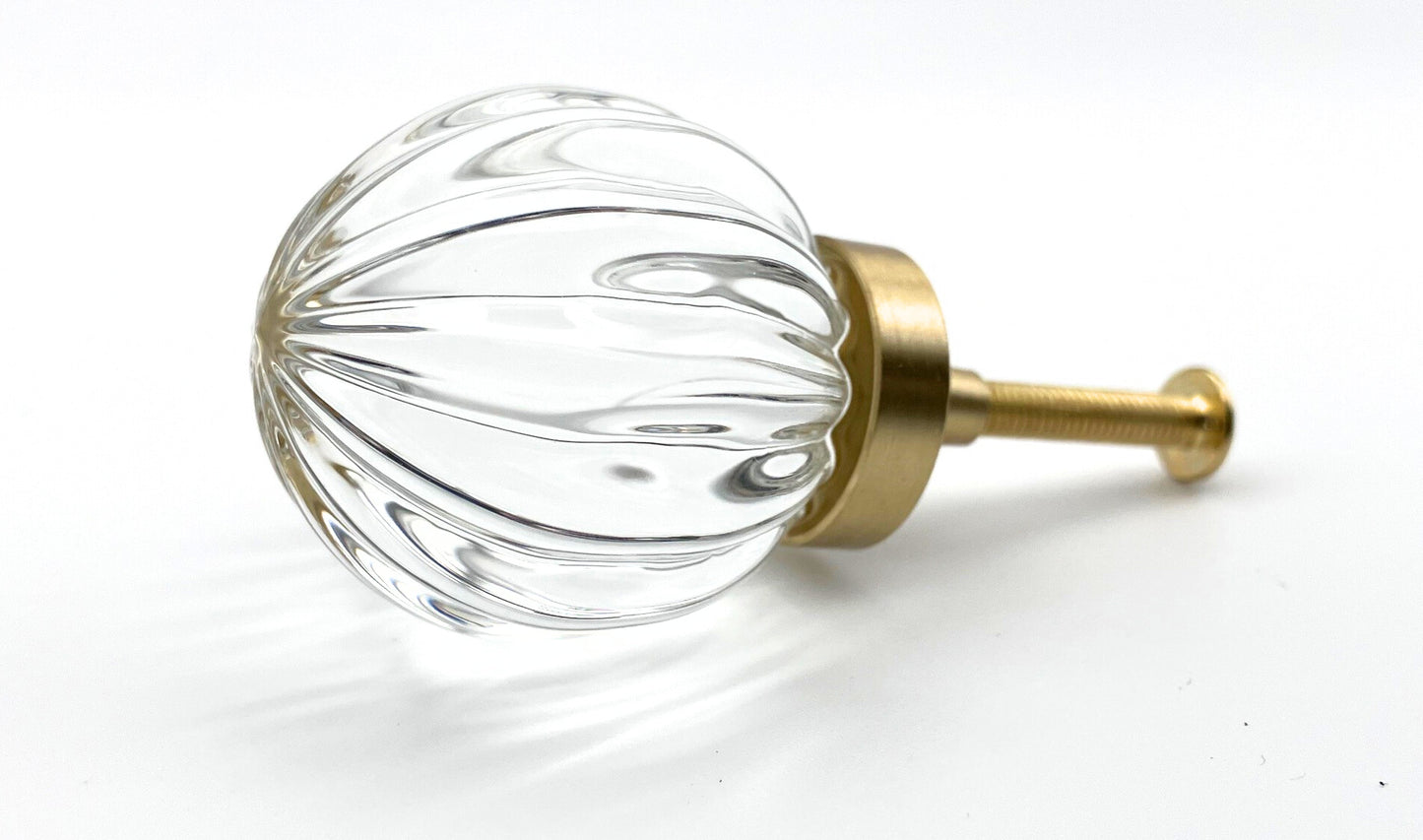 Clear glass knob with gold base on a white background