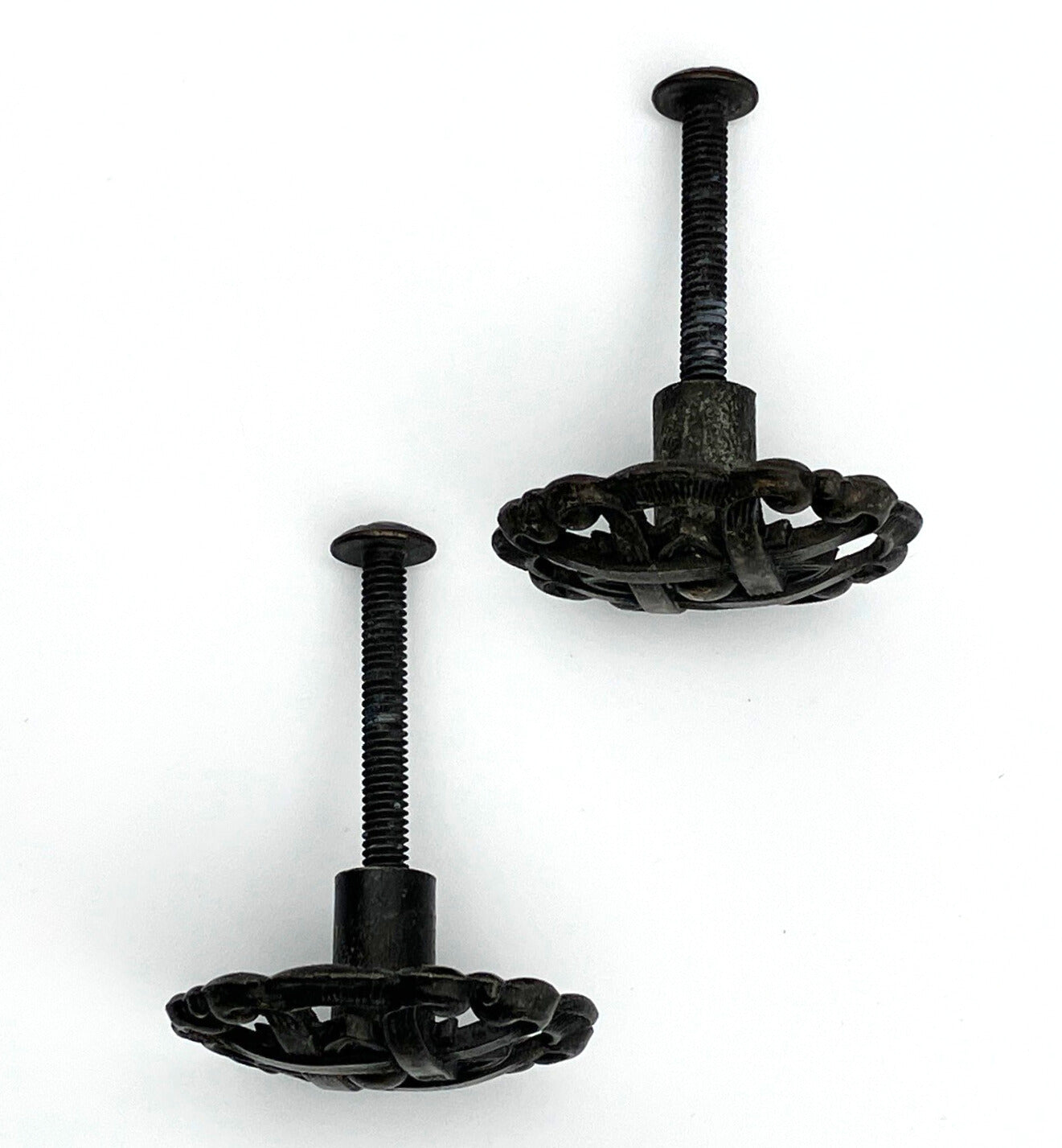 Two black metal knobs with pie-lattice design on white background