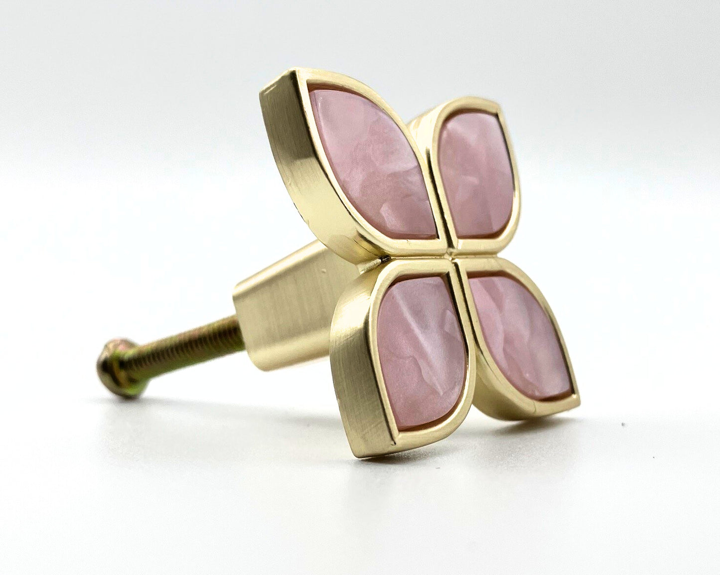 Decorative knob with pink stones and gold finish on a white background