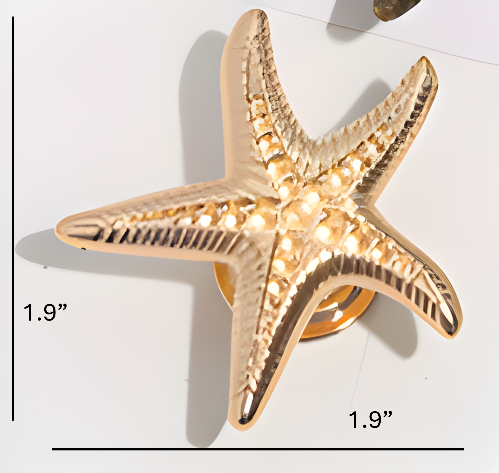 Gold starfish-shaped knob with measurements on a white background