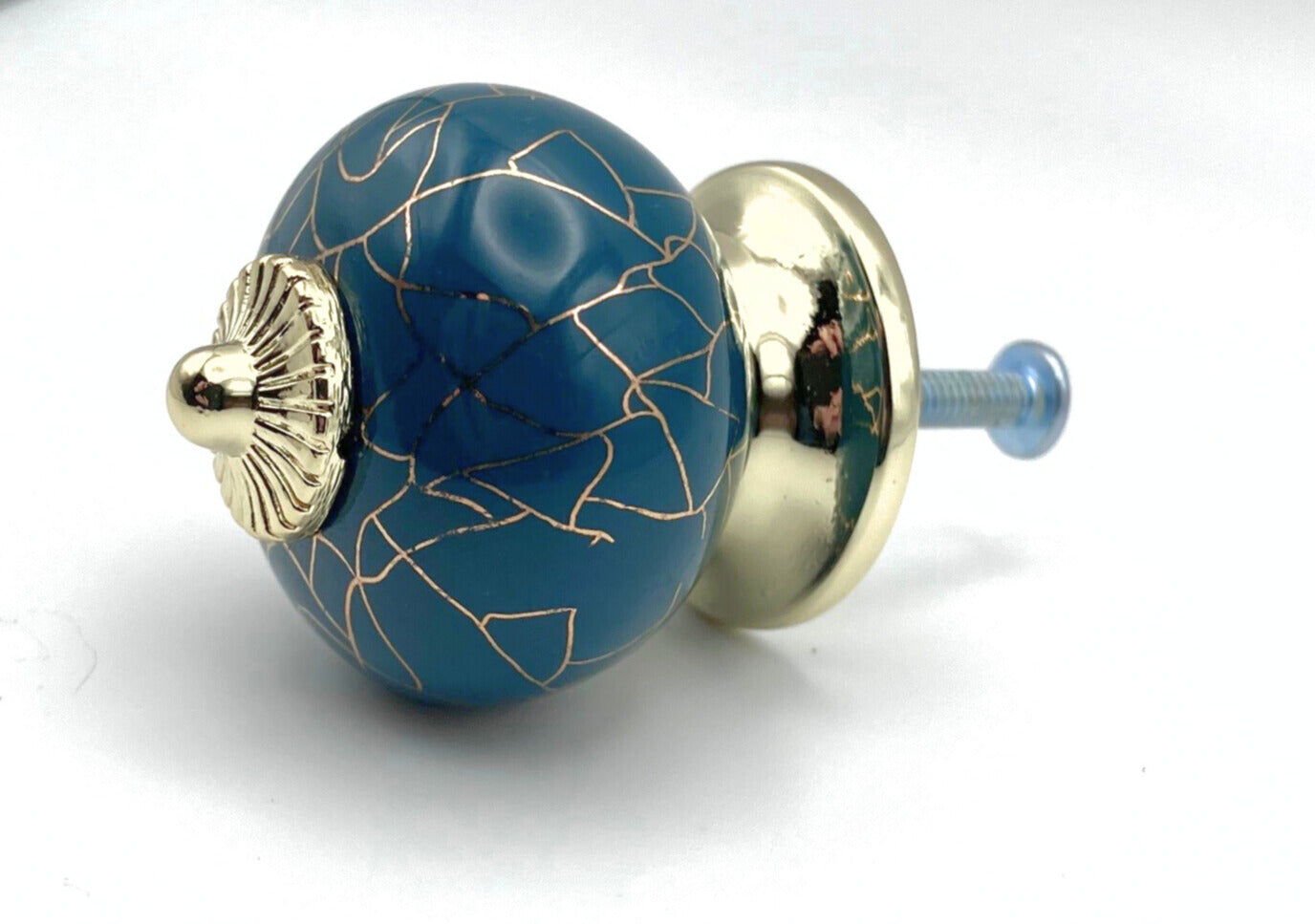 Decorative blue knob with gold accents on a white background