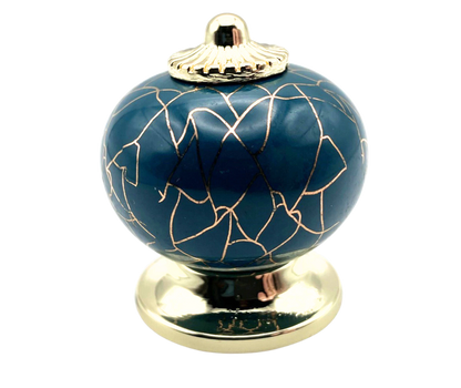blue round shaped knob with rose gold crackle design and gold metal hardware
