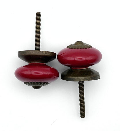 Two red ceramic cabinet knobs on a white background
