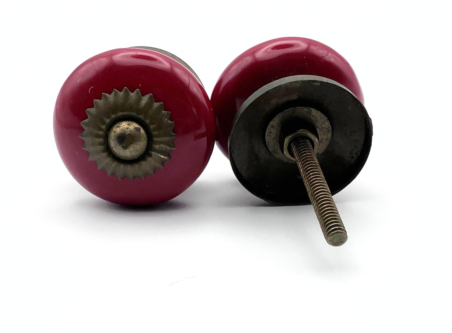 Two red knobs with metal cores on a white background