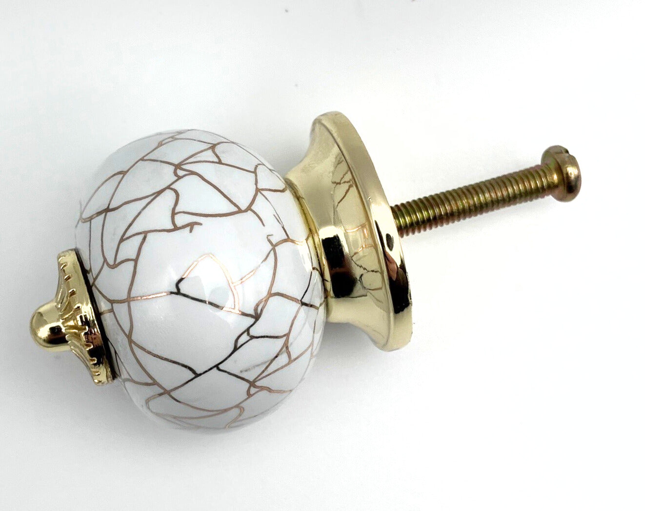 Decorative knob with gold and white design on a white background