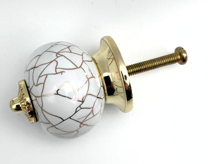 Decorative knob with gold and white design on a white background